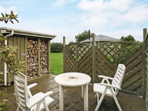 a patio with a table and chairs and a fence at 4 person holiday home in Vinderup-By Traum in Vinderup