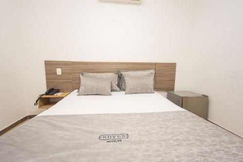 a bedroom with a large bed with a wooden headboard at Novus Laureles in Medellín