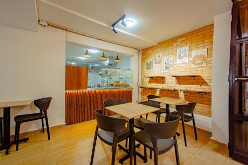 a restaurant with tables and chairs in a room at Novus Laureles in Medellín