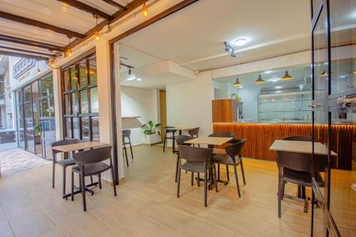 a restaurant with tables and chairs in a room at Novus Laureles in Medellín