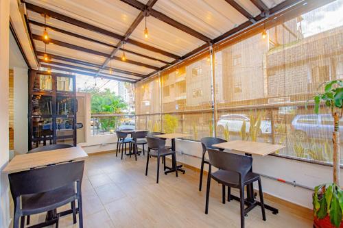 a restaurant with tables and chairs and a large window at Novus Laureles in Medellín