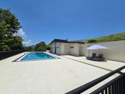a patio with a swimming pool and an umbrella at Sitio Uno Residences - Pueblo de Panay - F&M Homes in Roxas City