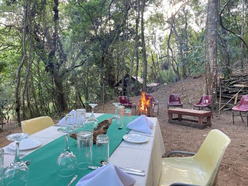 ベリハロヤにあるWild Paradise Camp Belihuloyaの森の中のテーブルと椅子と火