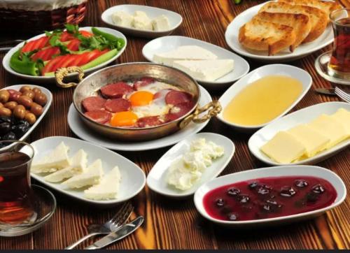 una mesa cubierta con platos de comida con huevos y queso en Indigo Apartments, en Yeda