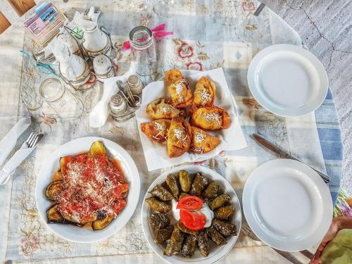 a table with plates and bowls of food on it at Diamanti Molivos Studios & Apartments in Mithymna