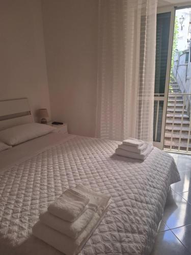 a white bedroom with a bed with towels on it at La maison del pescatore in Cetara