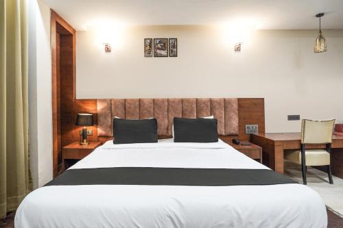 a bedroom with a large white bed and a desk at Hotel IBY Near Delhi Airport in New Delhi