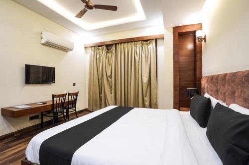 a bedroom with a bed and a desk and a television at Hotel IBY Near Delhi Airport in New Delhi