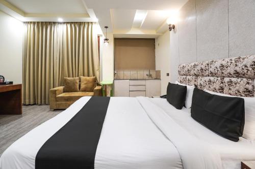 a hotel room with a large bed and a chair at Hotel IBY Near Delhi Airport in New Delhi