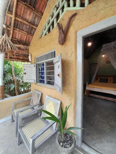 a resort patio with two chairs and a bed at Eco Retreat in Ahangama