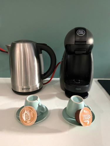 a tea kettle and two cups on a counter at Mint House in Niš