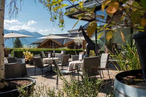 a restaurant with tables and chairs and mountains in the background at Hotel Tirol Fiss 4Sterne Superior in Fiss