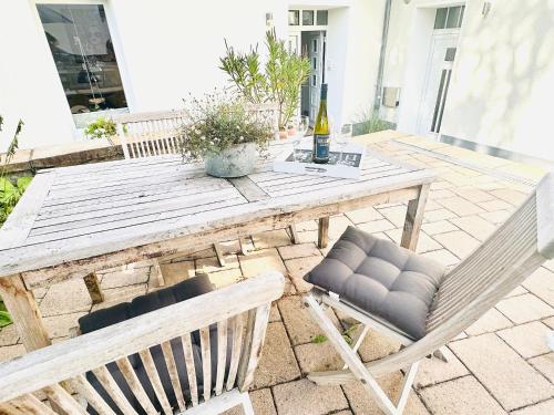 a wooden table with two chairs and a bottle of wine at Mola Apartments- Trendiges Apartment in der City-Nähe Dortmund-Terrasse-3 Gäste-WLAN in Herdecke