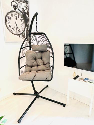 a swing chair in a room with a clock at Mola Apartments- Trendiges Apartment in der City-Nähe Dortmund-Terrasse-3 Gäste-WLAN in Herdecke