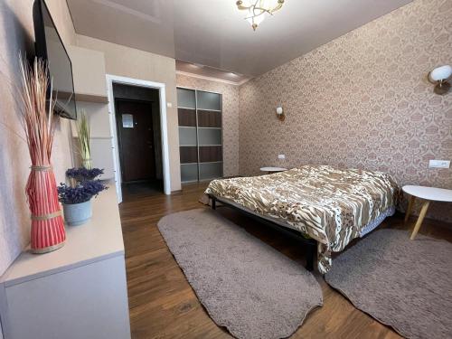a bedroom with a bed and a table and a rug at Apartamenty. Geroev Krut in Sumy