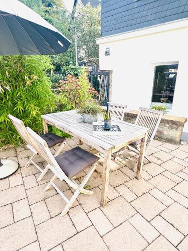 a wooden table with two chairs and an umbrella at Mola Apartments- Trendiges Apartment in der City-Nähe Dortmund-Terrasse-3 Gäste-WLAN in Herdecke