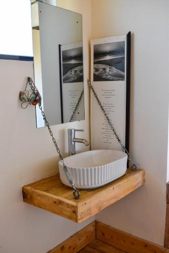 a bathroom with a bath tub chained to a mirror at Ole-lekurruki Naromoru Cabins in Naro Moru