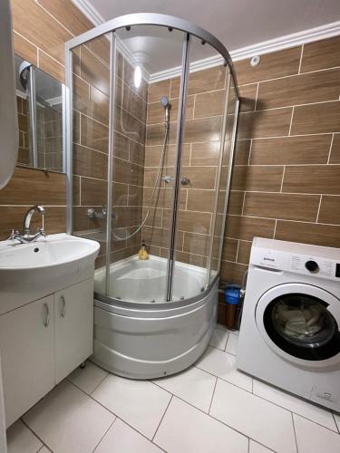 a bathroom with a shower and a washing machine at Apartamenty. Geroev Krut in Sumy