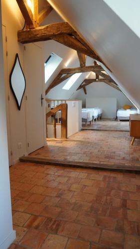 an attic room with several beds and exposed beams at Gîte Apolise in Saint-Rémy-la-Varenne