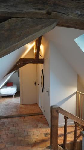 an attic room with wooden beams and a door at Gîte Apolise in Saint-Rémy-la-Varenne