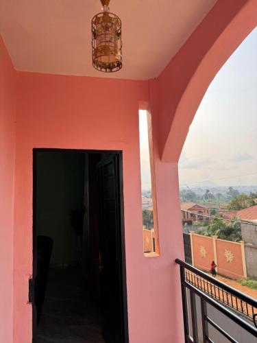 a view from the balcony of a house with a pink wall at Charming apartment in Yaoundé - Nkolmesseng in Yaoundé
