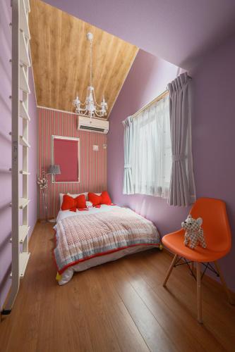 a bedroom with purple walls and a bed with an orange chair at Skytree View Rooftop Villa Asakusa SVRVA in Tokyo