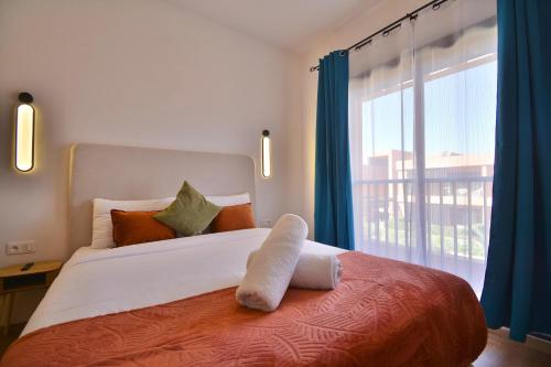 a bedroom with a large bed with a large window at Appartement Domaine de Noria in Marrakech