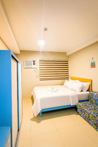 una habitación de hotel con una cama y una silla en The persimmon condominium studio, en Cebú