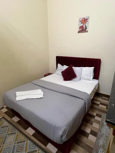 a bedroom with a bed with white sheets and red pillows at One Season Hotel in Cairo