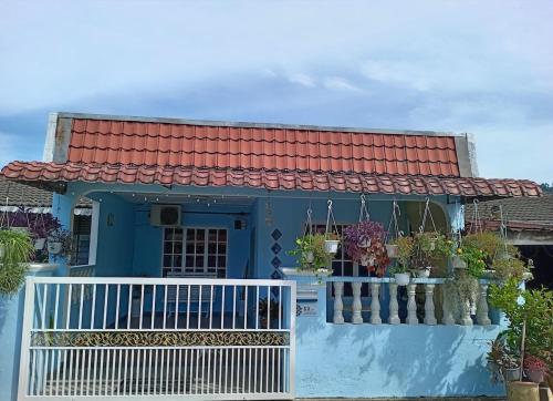 a blue house with a red roof and a balcony at Salza Homestay in Hulu Langat