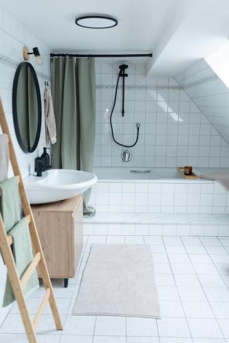 a bathroom with a tub and a sink and a shower at idyllisches Ferienhaus Reitlesmühl für 8 Personen in der Rhön in Oberthulba