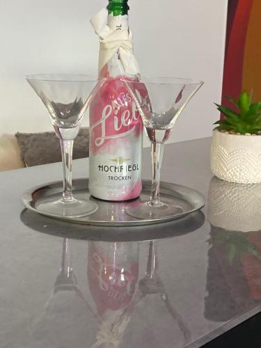 a bottle and two glasses on a table at O5 residence in Nivy