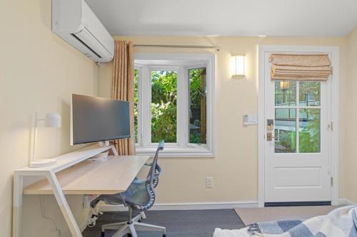 a home office with a desk and a computer monitor at Downtown Palo Alto Gem! Cute, Spotless Guest House in Palo Alto