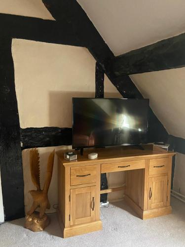 a television on a wooden stand in a room at Cefn Farm in Hyssington