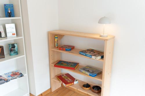 a book shelf with books and a lamp on it at idyllisches Ferienhaus Reitlesmühl für 8 Personen in der Rhön in Oberthulba