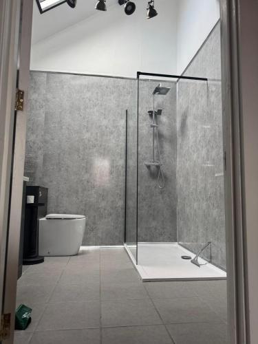a bathroom with a shower with a tub and a toilet at The workshop in King's Lynn