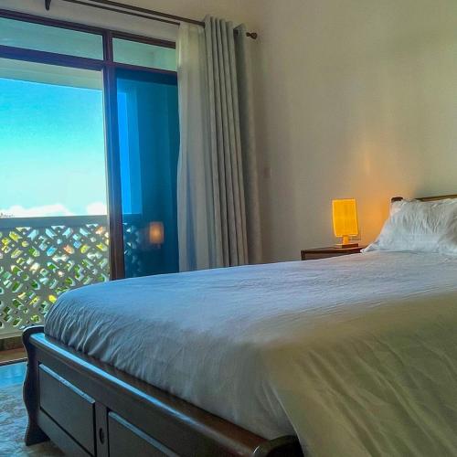 a bedroom with a large bed and a large window at Zuri's Beachfront Bliss, With Beach Access -Sultan Palace in Mtwapa