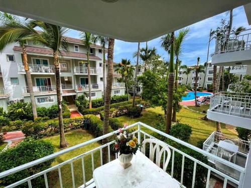 einen Balkon mit einer Blumenvase auf dem Tisch in der Unterkunft RELAX STUDIES DELUXE SOL CARIBE in Punta Cana
