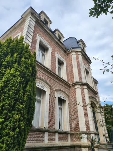 a large brick building with many windows on it at Hôtel De Ligny in Abbeville