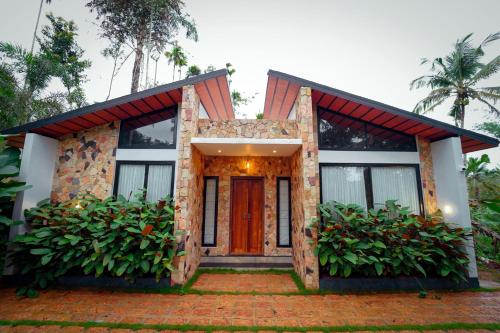 a house with a red door and some plants at wayanadjunglevillas in Kenichira