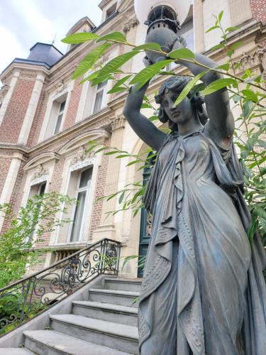 a statue of a woman holding a street light at Hôtel De Ligny in Abbeville