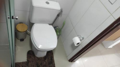 a white toilet in a bathroom with a roll of toilet paper at Comfortable and Elegant Apartment, in Santa Cruz de la Sierra