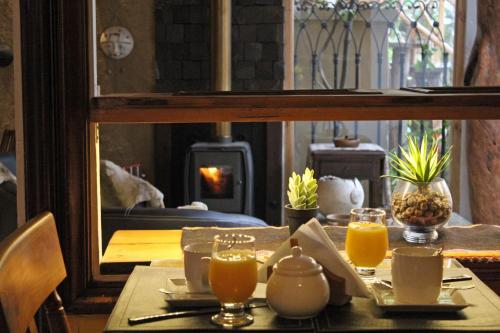 a table with glasses of orange juice and a fireplace at Hotel Boutique Terra Diaguita & Spa in La Serena