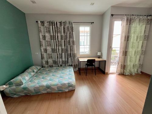 a bedroom with a bed and a desk and window at DJ Home in Ban Ko