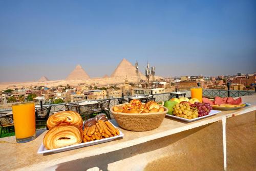 a buffet of food on a ledge with pyramids at Kayan Pyramids View in Cairo
