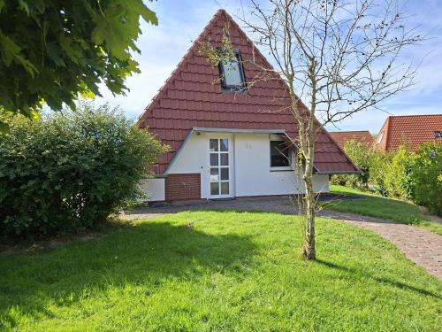 a small white house with a red roof at Weitblick in Dorum-Neufeld