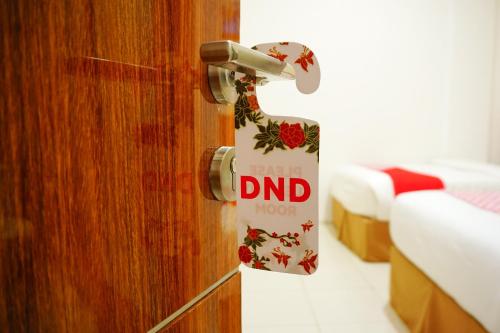 a door with a sign that reads dnd hotel at Hotel O Bukittinggi near Jam Gadang formerly Hotel Aedo in Bukittinggi