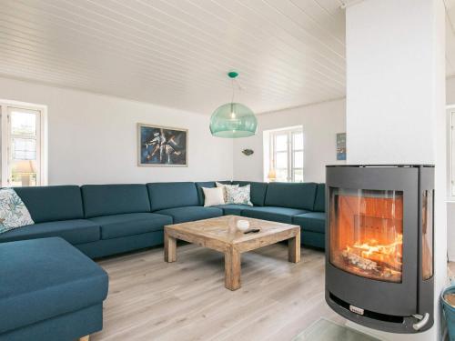 a living room with a blue couch and a fireplace at 16 person holiday home in Nykøbing M in Jørsby