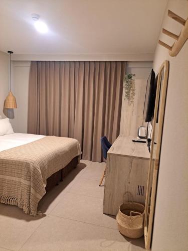 a bedroom with a bed and a flat screen tv at מלון המושבה כפר תבור in Kefar Tavor