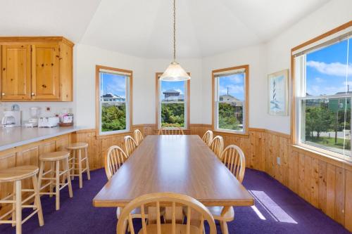 a dining room with a wooden table and chairs at 8455 - Mad Hatteras in Avon